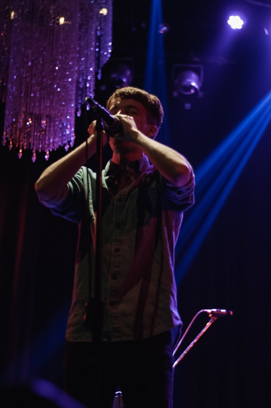 Federico Linari performing on stage under dramatic purple and blue stage lighting